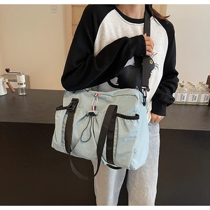 Dettaglio borsa casual blu in tela con tasca laterale e tracolle nere per ogni donna