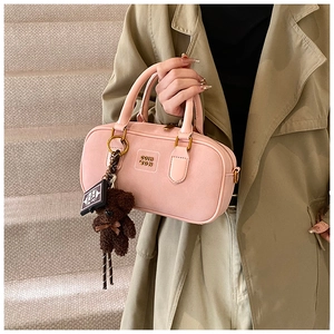 Pink Boston handbag with matte leather texture, gold logo and plush bear charm detail