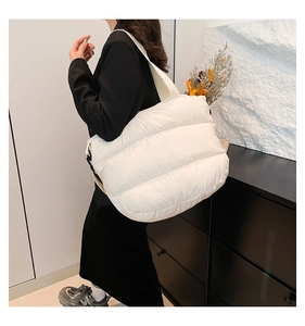 Vue latérale d'un sac cabas matelassé blanc porté par un mannequin au quotidien