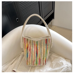 Detailaufnahme einer bunten gestreiften Webtasche auf einem weißen Sessel