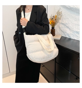 Détail du sac matelassé blanc avec bandoulière amovible porté par un mannequin