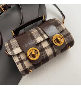 Dettaglio ravvicinato del tessuto scozzese vintage e delle chiusure dorate della borsa