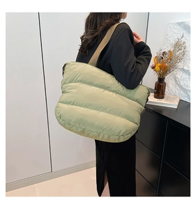 Détail du sac fourre-tout matelassé vert clair montrant sa grande capacité et sa bandoulière