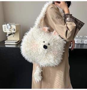 Detail view of the soft white faux fur texture and cute cartoon bear face on a plush bag