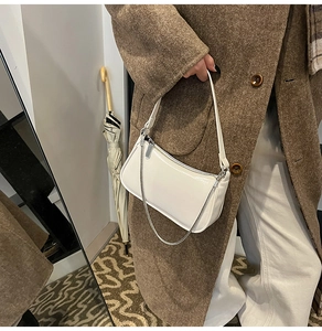 Detailansicht der weißen Lackleder-Baguette-Tasche mit modischer silberner Kette