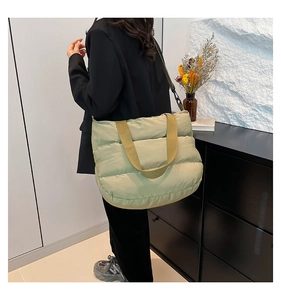 Détail du sac fourre-tout matelassé avec sangles jaune moutarde et tissu vert bouffant