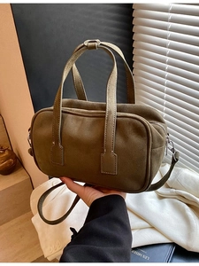 Green matte crossbody bag with top handles and adjustable strap in retro aesthetic
