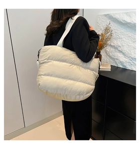 Détail du sac bandoulière matelassé crème montrant sa texture bouffante et sa grande taille