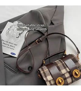 Dettaglio della borsa Boston scozzese retrò con cinturini in pelle e fibbie oro