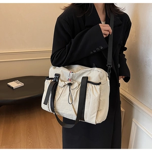 Dettaglio della borsa in tela con coulisse, fibbie e trama in nylon resistente all'usura