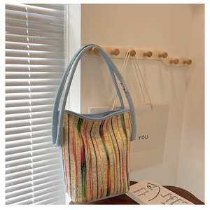 Detail der bunten gewebten Streifen und hellblauen Ledergriffe an der Boho-Tasche