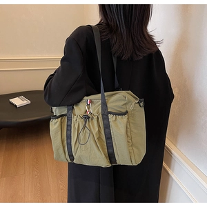 Vista posteriore di una borsa tote oversize in nylon verde oliva con spalline nere larghe