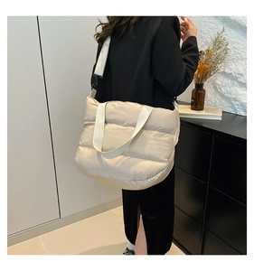 Détail du sac cabas matelassé beige avec texture nuage et bandoulière sur le mannequin