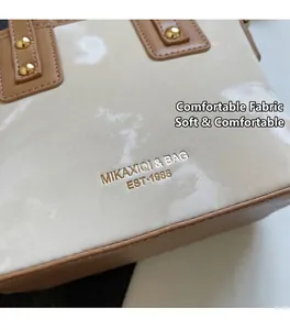 Detailansicht der cremefarbenen Marmortextur-Handtasche mit goldenen Nieten