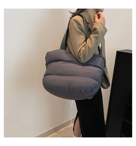 Détail des coutures latérales d'un grand sac cabas matelassé au style minimaliste