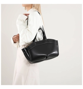 Fashionable black leather tote bag featuring white contrast stitching and spacious interior