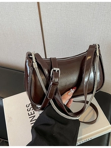 Retro dunkelbraune Lackleder-Achseltasche mit silberner Kette auf Magazin