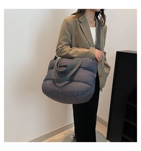Gros plan d'un grand sac cabas matelassé gris avec texture douce et bandoulière réglable