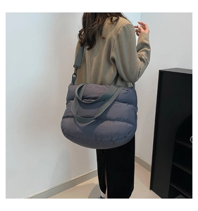 Détail d'un sac bandoulière matelassé bleu brume avec une large bandoulière