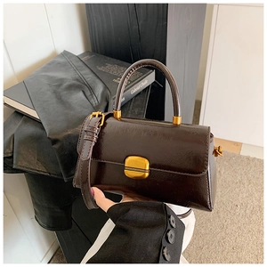 Dettaglio borsa a mano vintage marrone scuro in ecopelle con fibbia dorata lucida