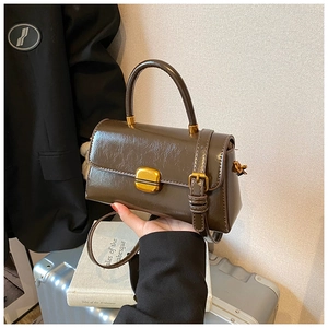 Dettaglio della borsa a tracolla vintage marrone scuro con chiusura in metallo oro