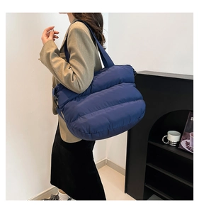 Détail du sac matelassé bleu foncé avec bandoulière large pour le trajet quotidien