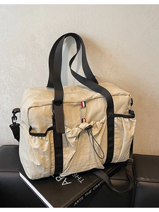 Grande borsa da viaggio beige in nylon con tracolla e strisce su panca nera