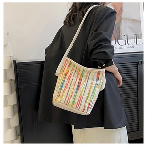 Detail der bunten gestreiften Strick-Beuteltasche mit weißen Lederriemen am Model