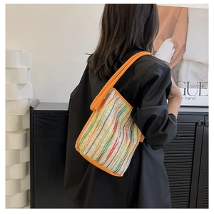 Bunte gestreifte Falten-Tote-Bag mit orangen Lederriemen an einem weiblichen Model