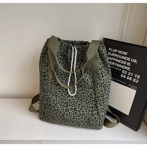 Detail of army green leopard print tote bag featuring a drawstring closure and web handles