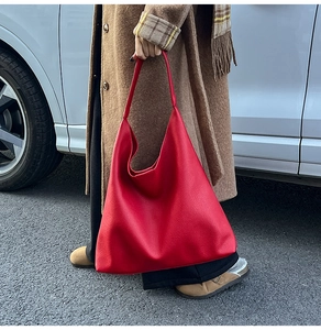 Detail of red tote bag with lychee pattern leather texture in a daily street setting