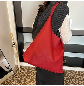 Detailed macro view of red lychee textured hobo tote bag on shoulder for daily commute