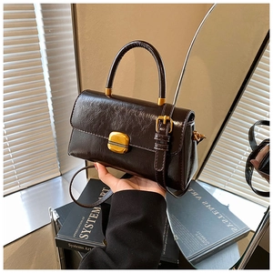 Dettaglio borsa vintage in pelle cerata con fibbia dorata e tracolla regolabile elegante