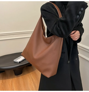 Close-up of brown pebbled leather tote bag with large capacity for winter outfits