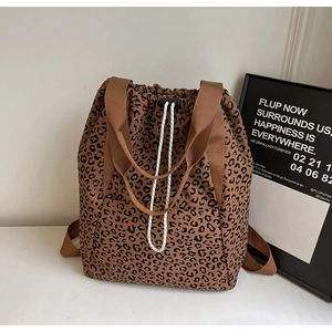 Macro shot of leopard print canvas bag detailing drawstring and brown nylon handles