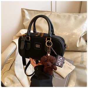 Detail of black nylon Boston bag with teddy bear charm and removable shoulder strap