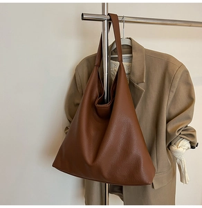 Close-up of pebble grain leather texture on a minimalist large brown tote bag
