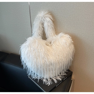Vue détaillée d'un sac à main blanc en forme de cœur avec une texture de plumes douces