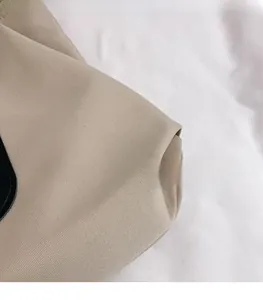 Close-up of durable beige canvas fabric with high-quality stitching on a large tote bag