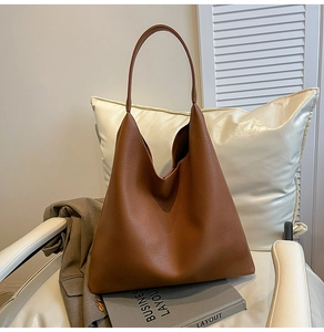 Detail of minimalist brown pebble leather tote bag on chair for office commute