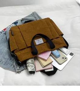 Brown corduroy crossbody bag with large front pockets showing spacious interior capacity