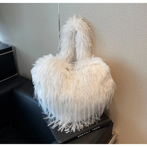 Gros plan du sac à bandoulière en fausse fourrure blanche en forme de cœur sur support