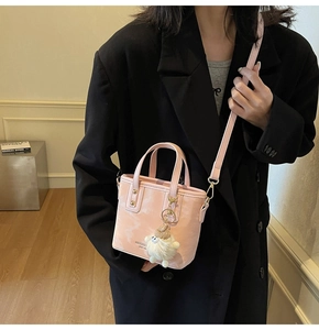 Detail der rosa Marmor-Eimertasche mit goldenen Nieten und Plüsch-Anhänger