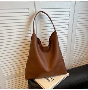 Detailed view of brown litchi textured faux leather on a large vintage tote bag