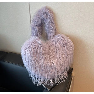 Gros plan sur un sac cabas en fausse fourrure lavande en forme de cœur à texture peluche
