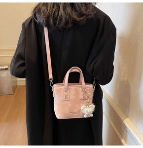 Detaillierte Rückansicht einer rosa Eimertasche mit Marmortextur und flauschigem Anhänger