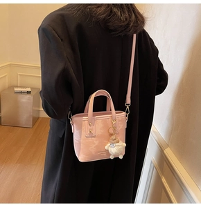 Rosafarbene Eimertasche aus Leder mit Wolkenstruktur und weißem Plüschschaf-Anhänger
