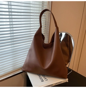 Detailed close-up of brown lychee texture leather on a large minimalist tote bag