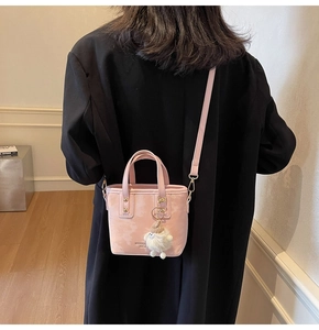 Rosa PU-Leder Eimertasche mit Metallnieten und einem weißen Plüsch-Schlüsselanhänger