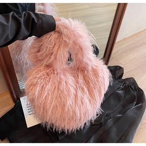 Vue détaillée de la texture en fausse fourrure rose clair d'un sac pelucheux à longues fibres